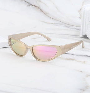 Detail view of champagne gold Y2K sunglasses with pink-yellow gradient lenses on marble