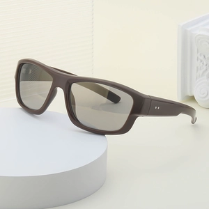 Lunettes de soleil Y2K marron avec verres foncés et clous argentés sur socle blanc