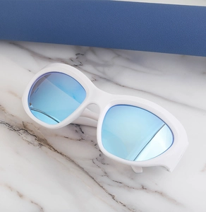 Détail de lunettes de soleil sportives blanches avec verres miroirs bleus sur marbre