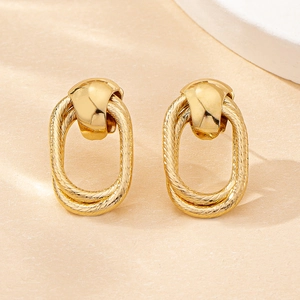 Macro view of vintage gold hollow oval earrings with twisted rope texture and polished finish