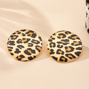 Close-up of elegant round leopard print stud earrings with golden brushed metal finish
