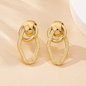 Macro shot of gold geometric drop earrings with hollow water-drop design and embossed texture