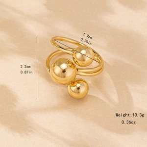 Elegant gold multi-layer wrap ring with polished beads on warm paper background