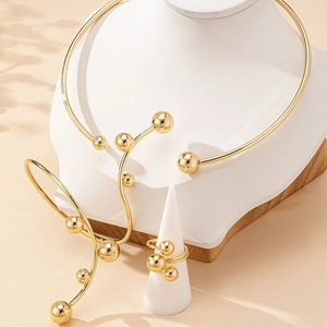 Parure de bijoux dorés élégants avec tour de cou, bracelet jonc et bague minimalistes