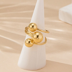Polished gold beaded ring featuring triple spheres and elegant spiral wrap design
