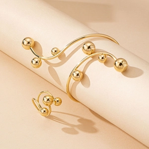 Ensemble élégant de bracelet et bague dorés avec perles métalliques sur fond neutre