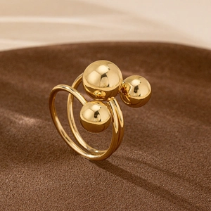 Elegant gold wrap ring featuring three polished metallic spheres for a modern minimalist look