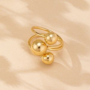 Detail of minimalist gold multi-layered ring featuring three polished metallic beads