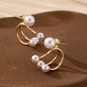 Elegant C-shaped gold stud earrings with clustered pearls for a modern French style