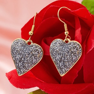 Romantic gold heart drop earrings with silver glitter on red rose petals