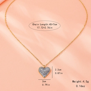Collana con ciondolo a cuore dorato e inserti scintillanti su velluto pesca