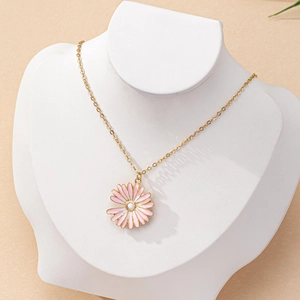 Fashionable gold daisy pendant necklace with pink enamel on a white jewelry bust