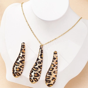 Elegant gold-tone leopard print teardrop necklace and earrings set on a display bust