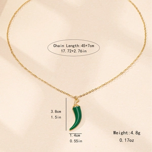 Collier en chaîne dorée avec pendentif piment en émail vert brillant sur fond beige