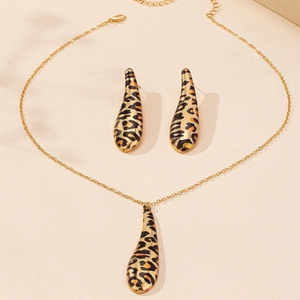 Detailed close-up of leopard print drop pendant necklace and matching earrings jewelry set