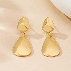 Détail macro des boucles d'oreilles léopard dorées avec pendentifs en poire