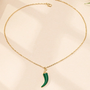 Détail d'un collier chaîne en or avec un pendentif piment en émail vert foncé