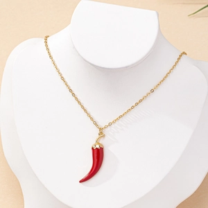Collier chaîne dorée avec pendentif piment en émail rouge sur présentoir à bijoux blanc