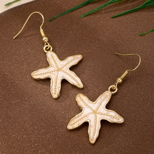 Boucles d'oreilles étoile de mer dorées avec émail blanc crème et crochet classique