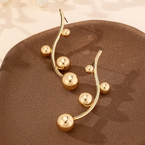 Elegant gold curved wave earrings with five polished beads on a premium display base