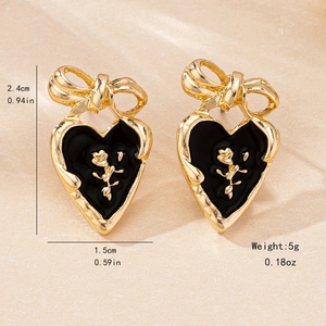 Golden heart earrings with black enamel rose and bow details for a romantic style