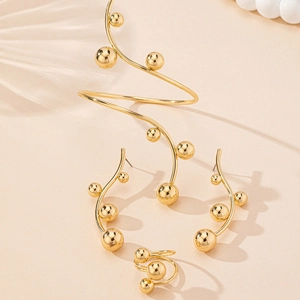 Detailed view of elegant gold beaded jewelry set featuring spiral arm cuff and earrings