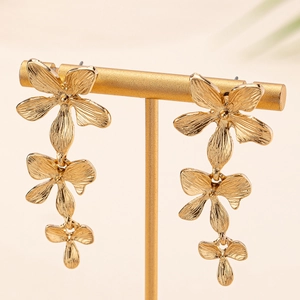 Eleganti orecchini pendenti a tre strati di fiori dorati su un supporto in metallo minimal