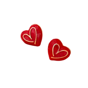 Boucles d'oreilles cœur en émail rouge avec bordure dorée sur fond blanc pur