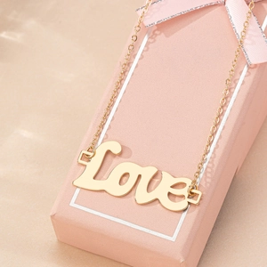 Collier élégant avec pendentif Love doré présenté sur une boîte cadeau rose
