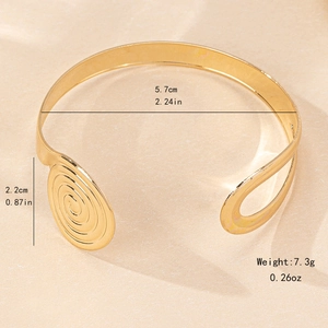Elegant gold spiral C-shaped open cuff bracelet featuring a minimalist geometric design