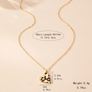 Fashionable gold chain necklace featuring leopard print heart pendant on beige background