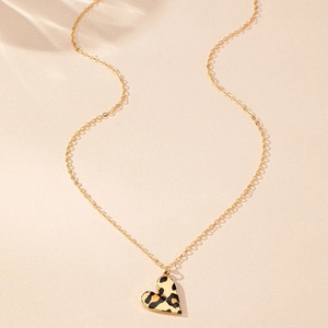 Macro shot of gold chain with leopard print heart pendant on textured background