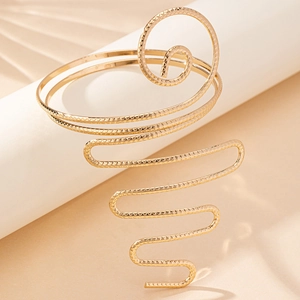 Elegant gold coiled snake arm cuff bracelet with intricate geometric engraved patterns
