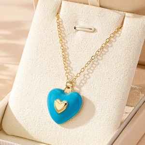 Collar con colgante de corazón de esmalte azul claro con cadena dorada en soporte