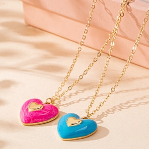 Collares bañados en oro con colgantes de corazón en esmalte rosa y azul sobre base texturizada