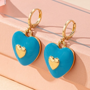 Detailed close-up of sky blue enamel heart earrings with gold metal accents