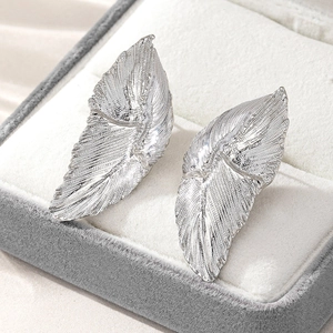 Elegant silver leaf stud earrings with detailed brushed metal texture in jewelry box