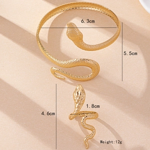 Golden snake-shaped bracelet and ring jewelry set with textured scales on beige backdrop