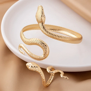 Golden snake-shaped jewelry set with textured scales, featuring a ring and open bracelet