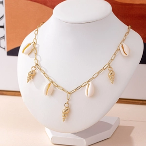 Elegant ocean style necklace featuring gold shells and white cowrie beads on a chain