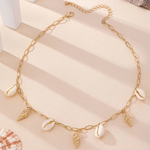 Detailed view of bohemian gold shell necklace with natural cowrie and spiral charms
