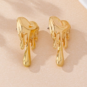 Gros plan sur des boucles d'oreilles cœur dorées avec design goutte de lave élégant