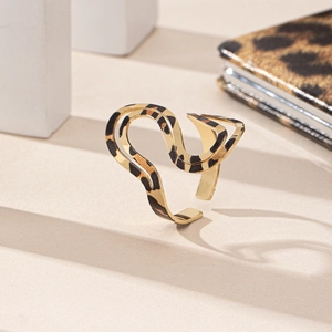 Irregular golden leopard print ring on minimalist white steps with wild fashion style