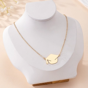 Golden graduation cap necklace with minimalist cross chain on a white neck display model
