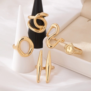 5-piece gold metal ring set with minimalist geometric designs on jewelry stands