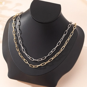 Minimalist paperclip link necklace set in gold and silver finish on a black bust