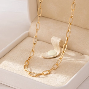 Golden paperclip link chain necklace displayed in a beige jewelry gift box for women