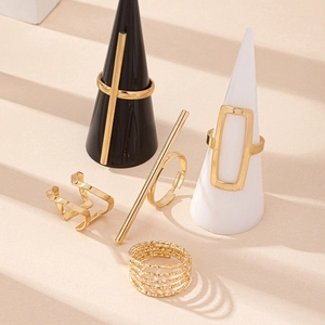 Five-piece gold geometric spring rings set with minimalist polished finish on beige stand