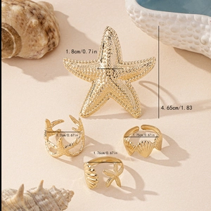 Set di 4 anelli dorati con motivi a stella marina, corallo e conchiglia per look da spiaggia