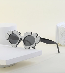 Detail of glitter flower sunglasses with silver shimmer on black frames for party